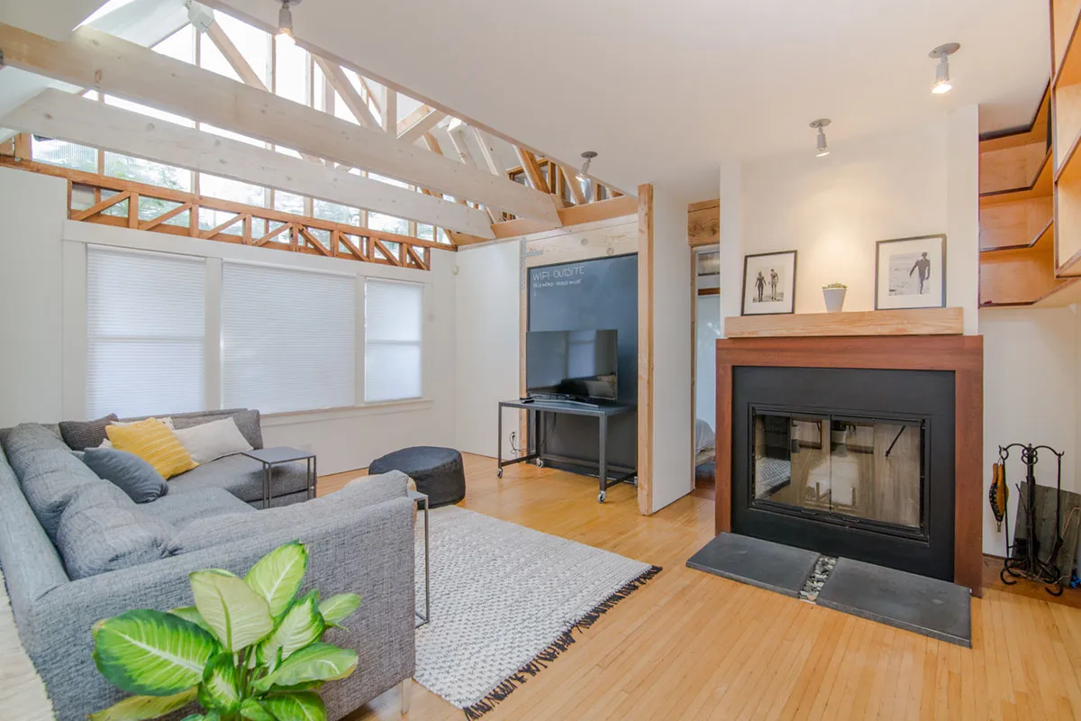 A bright modern living room with a fireplace and large windows