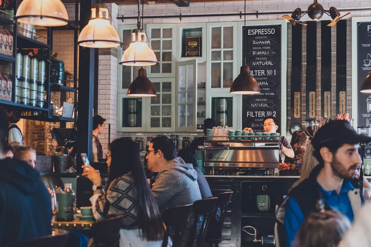 A busy coffee shop interior with customers seated at the counter
