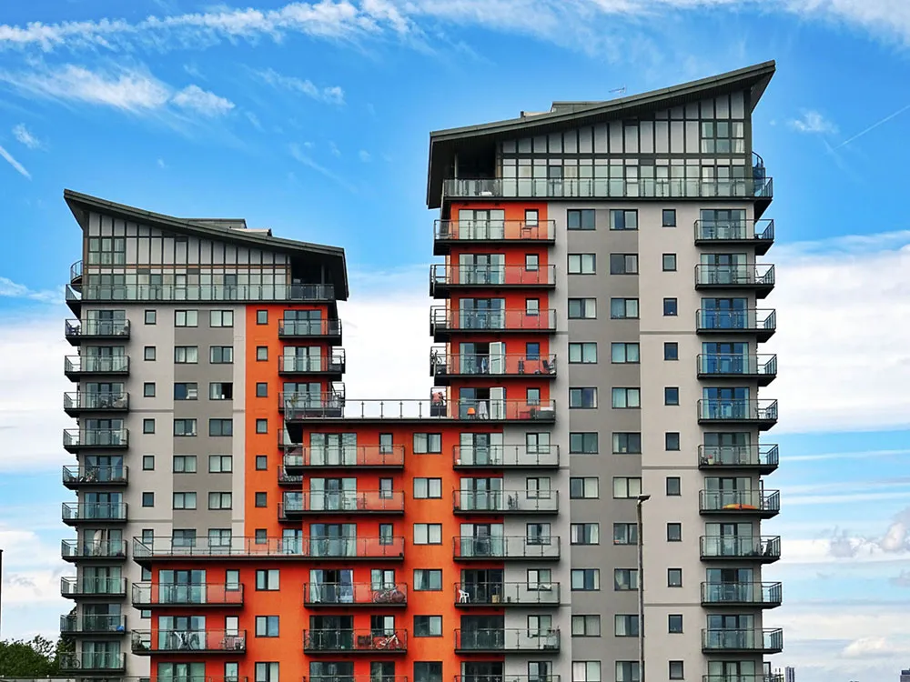 A tall red and white high-rise apartment building